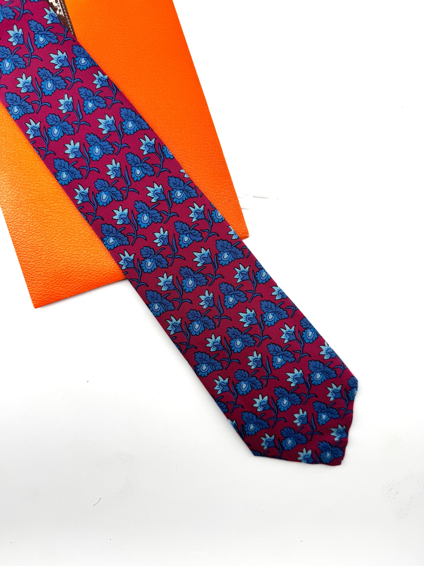 Cravate Hermès en twill de soie – fond bordeaux, motif floral en camaïeu bleu