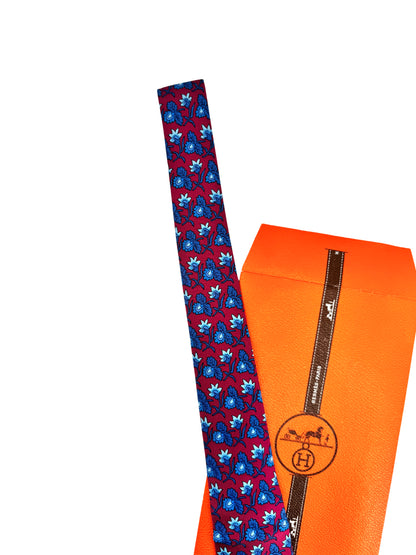 Cravate Hermès en twill de soie – fond bordeaux, motif floral en camaïeu bleu