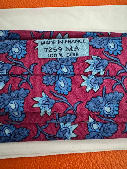 Cravate Hermès en twill de soie – fond bordeaux, motif floral en camaïeu bleu